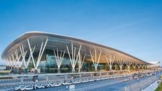 an airport with cars parked in front of it and the building is made of metal