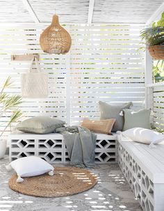 an outdoor area with white furniture and pillows