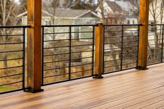 a wooden deck with black iron railings and wood posts