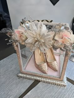 two pairs of shoes are sitting on a table with flowers in the middle of it