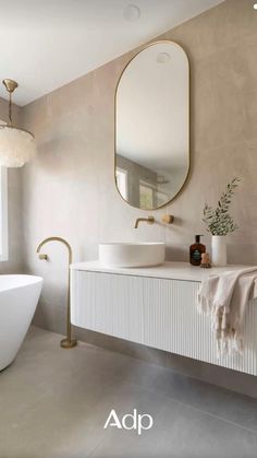 a bathroom with two sinks, a bathtub and a large mirror on the wall