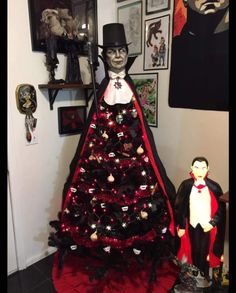 a decorated christmas tree with a man in top hat and cape standing next to it