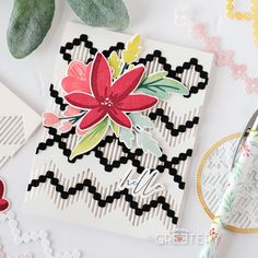 a close up of a flower on a card with scissors and other crafting supplies