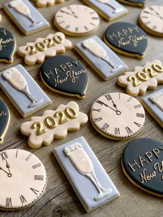 decorated cookies with the words happy new year written on them are displayed in front of a wooden table