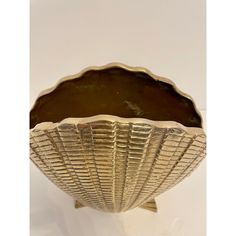 an antique brass shell shaped bowl on a stand