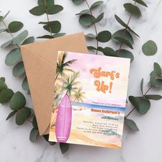 a pink surfboard is on top of a card next to some green leaves and a brown envelope