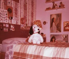 a dog sitting on top of a bed in a room with pictures and other items