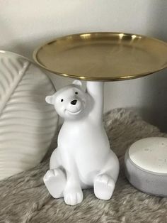 a white polar bear figurine sitting next to a gold tray on a table