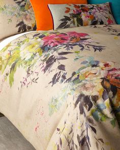 a bed covered in a floral comforter and pillows