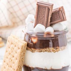 a jar filled with chocolate and marshmallows on top of a white table