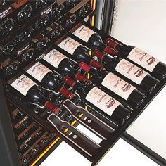 a bunch of wine bottles are stacked on top of each other in a rack,