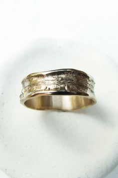 a close up of a gold ring on a white surface with the word love written in it