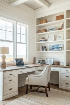 a home office with built in shelving, desk and chair next to the window