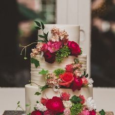 a three tiered wedding cake with flowers on it