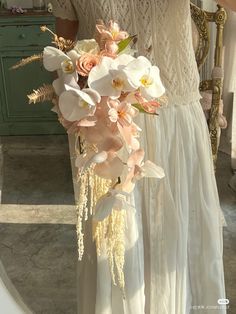 a woman in a white dress holding a bouquet of flowers