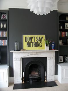 a living room with a fire place and a don't say nothing sign on the fireplace