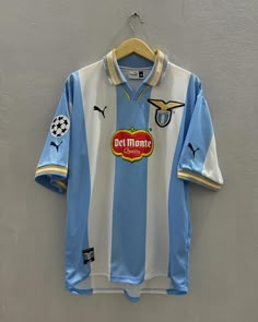 a blue and white soccer jersey hanging on a wall