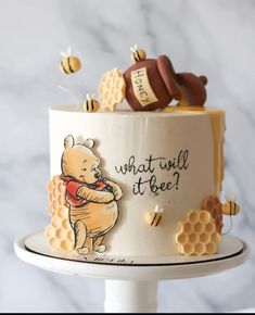 a winnie the pooh birthday cake with honeycombs and bees on top that says, what will it bee?