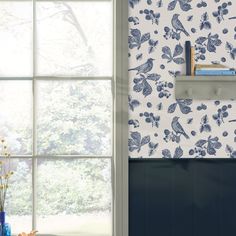 a blue and white wallpaper with birds on it next to a window sill