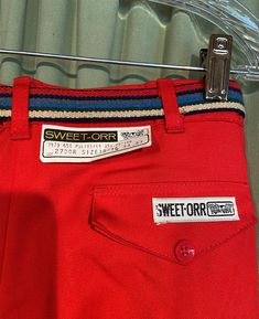 "This is a fun pair of vintage pants from the 1970s or early 80s. These are deadstock with tags still attached. Tagged, \"Sweet-Orr\". Tagged a size 15/16, waist 34, inseam 33. Actual measurements are a little smaller . Waist measures 33. Made of 65% polyester & 35% cotton in bright red. The trousers are high waisted with a metal zipper & button on the waist band & a pleated front. It has belt loops on the waist band & a striped, stretch elastic belt with metal disc buckle. They Retro Red Cotton Bottoms, Vintage Red Pants With Pockets, Retro Red Workwear Bottoms, Retro Red Bottoms For Workwear, Retro Red Cotton Pants, Retro Red Pants For Workwear, Retro Red Bottoms For Work, Retro Red Pants For Work, Shirts Style