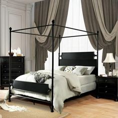 a bedroom with a four poster bed and black furniture