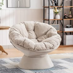 a round chair sitting on top of a rug in a living room next to a table