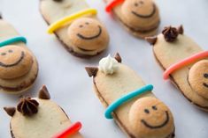 there are many decorated cookies with faces on top of each cookie and one has a toothbrush in its mouth