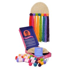 an assortment of colorful crayons in a pink case with a rainbow decoration on top