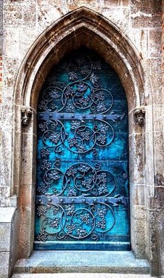 an ornate blue door with intricate carvings on it's sides and the top part of its arch