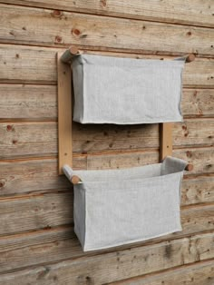 two linen storage bins mounted to the side of a wooden wall