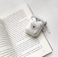 an open book with ear buds attached to it