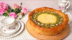 there is a cake on the table with pink flowers and tea cups next to it