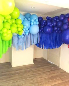 a room with balloons and streamers hanging from the ceiling, along with wood flooring