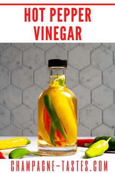 hot pepper vinegar in a glass bottle with peppers around it and the words, hot pepper vinegar