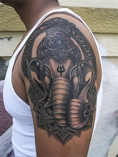 an elephant tattoo on the arm and shoulder is shown in black and grey colors with intricate details