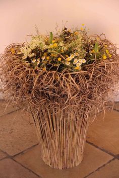 there is a basket with flowers in it on the floor next to a tile floor