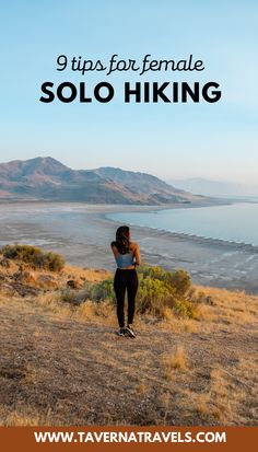 a woman standing on top of a grass covered hill next to the ocean with text overlay