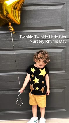 a little boy standing in front of a door with a star t - shirt on