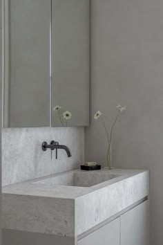 a white bathroom sink sitting under a mirror next to a wall mounted faucet