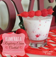 raspberry cream cocktail in a glass with strawberries on the top and rumchata sign behind it