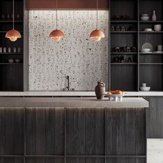 a kitchen with black cabinets and marble counter tops, two hanging lights above the island