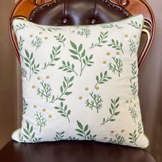 a white pillow sitting on top of a wooden chair