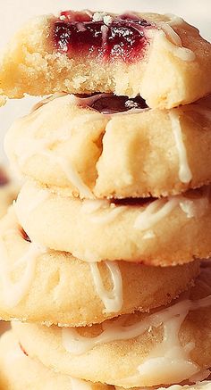 a stack of cookies sitting on top of each other with icing and jelly toppings