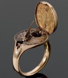 1570: A rare 16th century gold sundial and compass ring, possibly German,  The hinged oval bezel designed as a seal and engraved with a coat of arms, opening to reveal a sundial and compass, on a plain gold hoop. Is it weird that I want one of these? So much more elegant than checking your phone. Compass Ring, Sundials, Dieselpunk, 16th Century, Gold Hoop, In The Middle, Artifacts