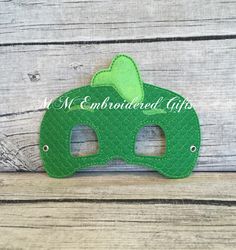 a green mask is sitting on a wooden surface