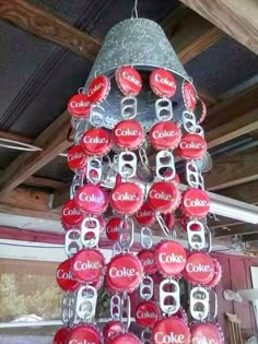 a christmas tree made out of coca cola cans is hanging from the ceiling in a garage