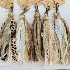 three different types of tassels are hanging on a wooden board with tags attached to them