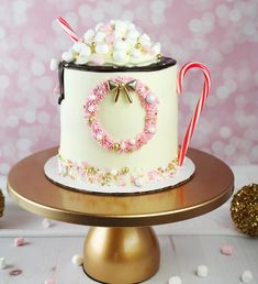 a decorated cake with candy canes and candies on the top is sitting on a gold plate