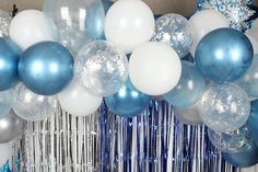 blue and white balloons are hanging from the ceiling