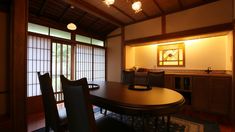 a dining room table and chairs in front of an open window with sliding glass doors